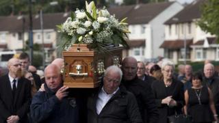 Mourners carry the coffin of Seamus Wright at his funeral