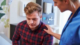 Nurse reassuring a male patient