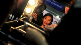 A customer (C) is attended to by a make-up artist (R) during the 5th Korea Beauty and Cosmetic Expo in Goyang, north of Seoul on September 14, 2013