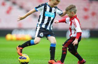 Two young footballers in Newcastle and Sunderland strips