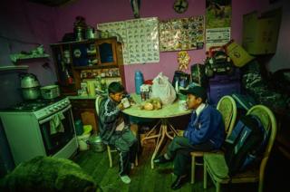 Two brothers sit at their kitchen table