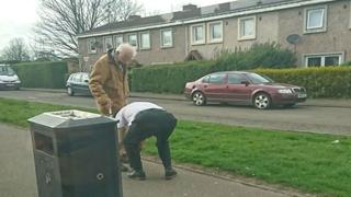Bus driver tying man's shoe lace
