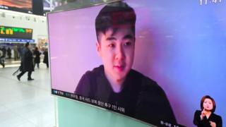 Una pantalla de televisión vista desde la calle en la que se ve el video del supuesto hijo de Kim Jong-nam.