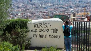 Barselonada "Turist. Sizin lüks səyahətiniz, bizim gündəlik əziyyətimizdir" yazısı.
