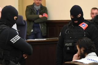 Salah Abdeslam sits surrounded by Belgian special police officers in the courtroom at the Palais de Justice courthouse in Brussels.
