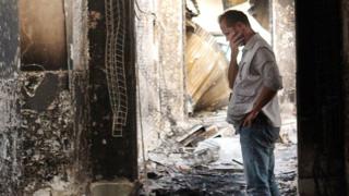 MSF employee inspects damaged clinic