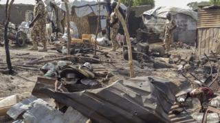Nigerian troops during the visit of Chief of Army Staff, LT. Gen. Tukur Buratai patrol the aftermath of a bombing allegedly carried out by the Nigerian Army at a government run camp for internally displaced persons in Rann, Nigeria, 20 January 2017
