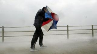 Dyn yn brwydro yn erbyn y storm