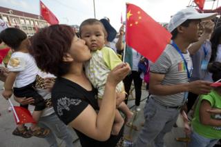 A woman kisses a baby after Beijing was announced as the host city for the 2022 Winter Olympics at the ski resort region of Chongli where the Nordic skiing, ski jumping, and other outdoor Olympic events will be held in northern China's Hebei province Friday, 31 July 2015.