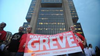 Bancários erguem cartaz de greve em frente a sede do Banco Central, em Brasília, em 2014