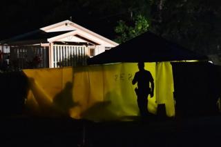 Police officers at the crime scene where the eight children were found dead