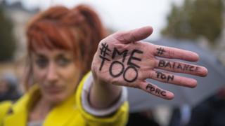 一名参与"#我也是"(#metoo)的女性展示手中的涂鸦