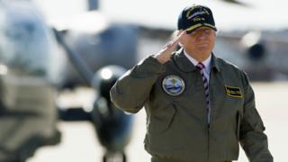 US President Donald Trump salutes as he walks to Air Force One prior to departing from Langley Air Force Base in Virginia - 2 March 2017