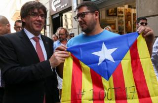 Katalonya Bölgesi hükümerinin lideri Carles Puigdemont (solda), bağımsızlık yanlısı bir vatandaşla kameralara poz veriyor