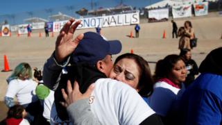Familiares abrazándose en la frontera de Estados Unidos y México.