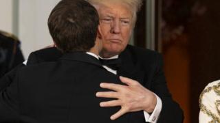 Donald Trump and Emmanuel Macron embrace