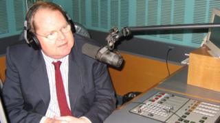 Mark Colvin sits in front of a radio microphone at the Australian Broadcasting Corp