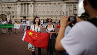 Chinese tourists have their pictures taken outside Buckingham Palace on July 29, 2012 in London, England