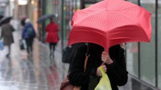 A shopper with a red umbrella