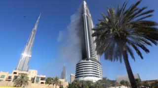 Plumes of smoke rise from the 63-storey Address Downtown hotel and residential block near the Burj Khalifa, a day after the hotel caught fire on New Year's Eve,