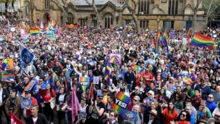 Protestors gathering in central Sydney, thousands are seen with signs and rainbow flags