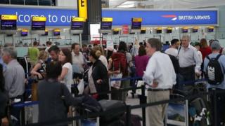 People queuing at check in at Heathrow Airport