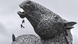 Three men inspecting Kelpies