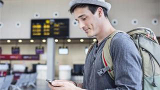 hombre usando teléfono móvil en el aeropuerto.
