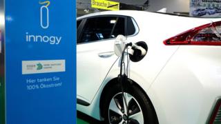 An electric car connects with a charger during a motor show in the western German city of Essen