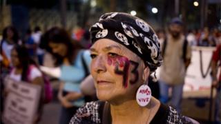 A woman with the number 43 painted on her face, referring to the 43 missing students from a rural teachers college, participates in a march in Mexico City, Thursday, Nov. 26, 2015