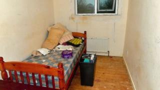 Habitación de la víctima con una cama pequeña y un tacho de basura.