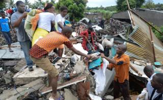 People search for survivors and belongings under collapsed piles of rubbish in Maputo, Mozambique, 19 February 2018