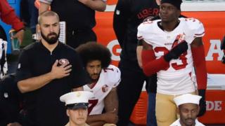 NFLサンフランシスコ・フォーティーナイナーズのキャパニック選手(中央)は1日も国歌演奏で起立せず、代わりにひざまずいた