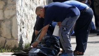 Israeli medics carry away the body of a Palestinian man who attempted to stab a soldier in the East Jerusalem Jewish settlement of Armon Hanatsiv, adjacent to the Palestinian neighbourhood of Jabal Mukaber, on October 17, 2015