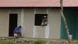Two former rebels work on building the hotel