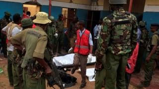 Police officers stand by dead bodies after an attack by Islamist militants from the Somali group al Shabaab in Mandera, Kenya, October 6, 2016