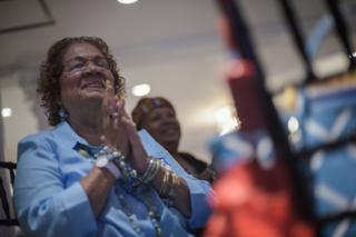 Woman praying for Hillary