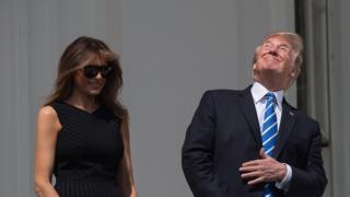 US President Donald Trump, with First Lady Melania Trump at his side, looks up at the partial solar eclipse from the balcony of the White House in Washington, DC, on August 21, 2017