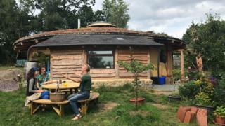 Soma, Janta, and Merav Wheehouse at their straw bale roundhouse