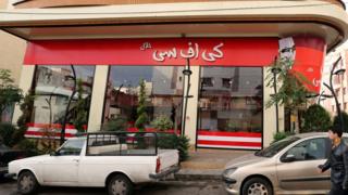 A man walks past the fried chicken shop "KFC Halal", after it was closed by Iranian police