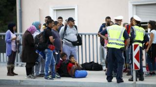 Migrants walking from Slovenia speak to police officers as they arrive to the border town of Bad Radkersburg, Austria, on 20 September.