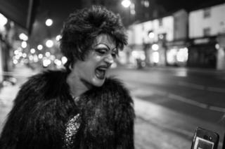 A drag queen laughs