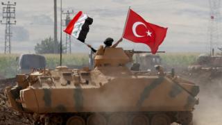 Tankın üzerinde Türk ve Irak bayrağı sallayan bir asker