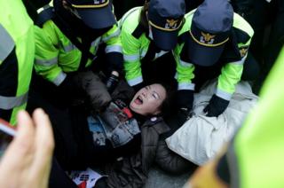 Police officers scuffle with protesters as they demand the arrest of ousted South Korean President Park Geun-hye, in front of her private home on 30 March 2017 in Seoul, South Korea.