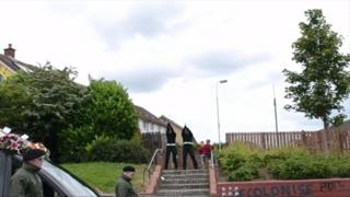 Shots fired at west Belfast funeral video