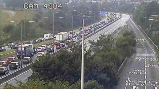 Traffic is queuing on the eastbound carriageway at Llandarcy