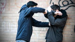 Staged scene of two teen youths fighting