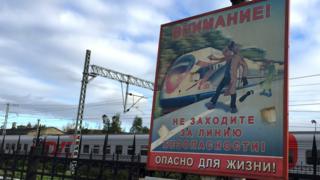 Предупреждающий о следовании скоростного поезда знак на железнодорожной платформе