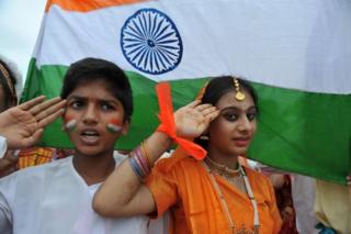 In this photograph taken on August 30, 2012, Indian school children salute as they stand to attention and sing the national anthem "Jana Gana Mana" in Hyderabad.