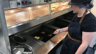 Staff member cooks at fryer